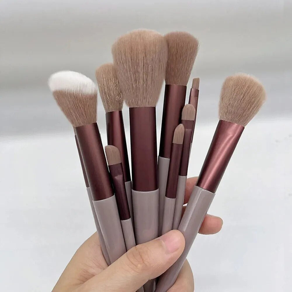 Femme montrant les 13 pinceaux de maquillage couleur rouge