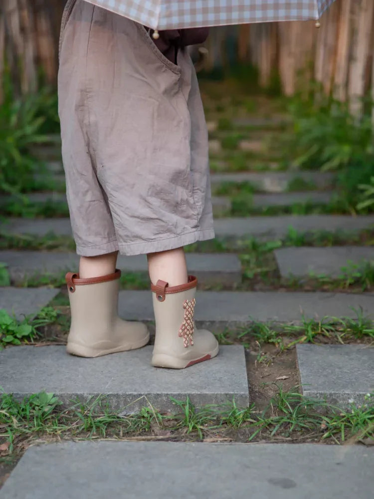 Enfant portant les bottes imperméables