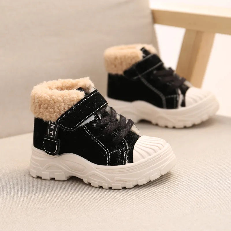 Paire de bottes chaudes pour enfants Hiver de couleur noir positionnée sur une chaise 