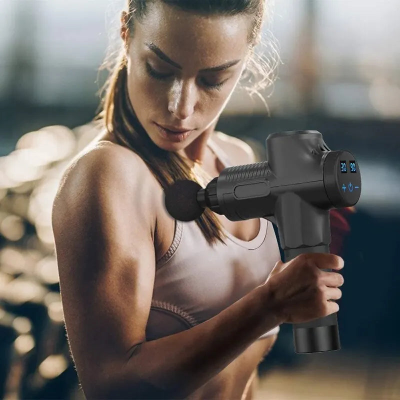 Femme sportive utilisant le pistolet de massage sur les muscles de son bras.